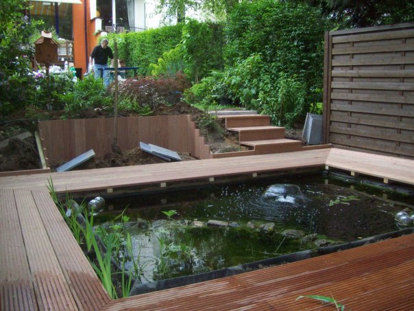 Après pièce d'eau + terrase en bois et palissade de bois